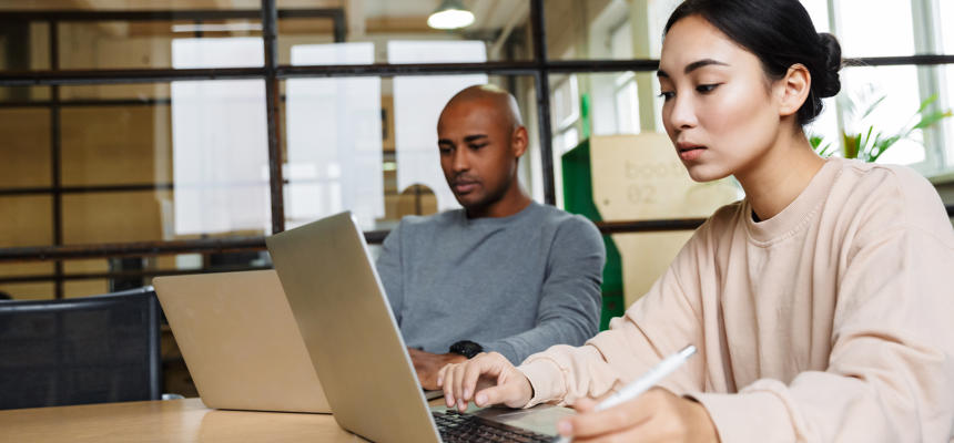 two professionals on laptops